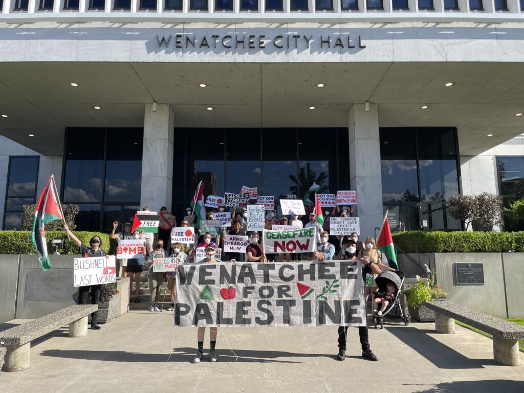 Over 50 protesters gather in front of Wenatchee City Hall, holding Palestinian flags and signs that say things like "Not Another Bomb"